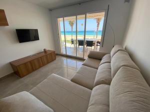 - un salon avec un canapé et une vue sur la plage dans l'établissement Valentina Platja, à Sant Antoni de Calonge
