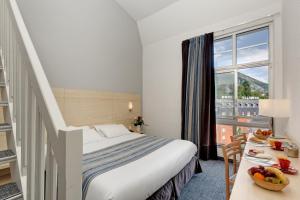 a hotel room with a bed and a window at Hôtel Alba in Lourdes