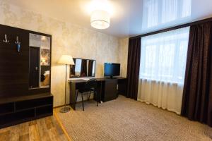 a hotel room with a desk and a television at Siyaniye Hotel in Syktyvkar