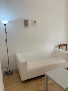 un soggiorno con divano bianco e lampada di La Casa del Dottore a Rapolla