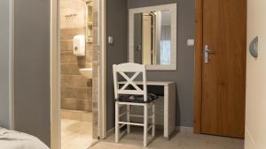 bagno con specchio e sedia bianca di Casablanca a Niš