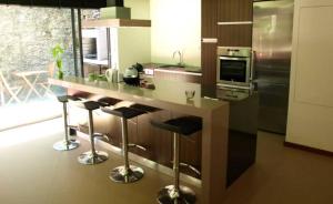 a kitchen with a counter with stools and a stove at Casa de Beiral in Geres