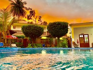 a swimming pool in front of a house at São Pedro Guesthouse in São Tomé