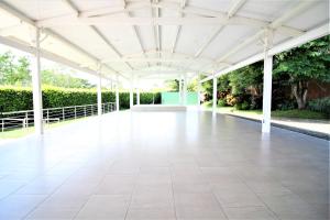 a white pavilion with a white floor and trees at Amazilia Hotel in Pereira