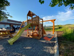 a playground with a slide and two chairs at Apartman Fenestra s terasom i pogledom na Gacku in Otočac