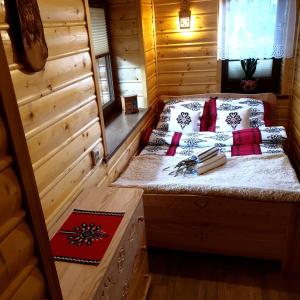 pokój z łóżkiem w drewnianym domku w obiekcie Apartamenty u Baców w mieście Ostrowsko
