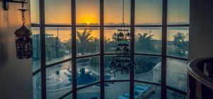 a window with a view of a pool and the sunset at The Precious Guesthouse in Sowayma