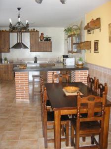 a kitchen with a table and chairs and a kitchen with a stove at Casa de La Paca in Coca
