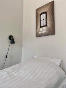 1 dormitorio con 1 cama y ventana en la pared en Hjalmar’s Hotel, en Korpo