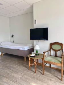 um quarto com uma cama, uma cadeira e uma mesa em Hjalmar’s Hotel em Korppoo