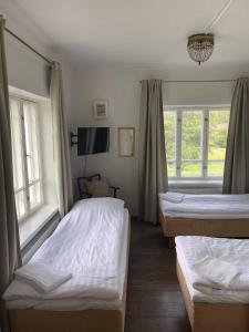 a room with two beds and two windows at Hjalmar’s Hotel in Korppoo