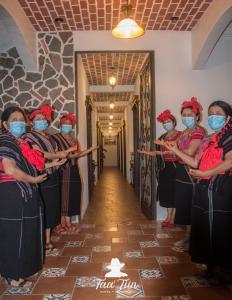 een groep vrouwen in een gang met maskers op bij Hotel Taa' Tiin in San Juan La Laguna