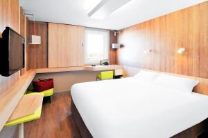 a hotel room with a bed and a tv at Ibis Styles Lille Marcq En Baroeul in Marcq-en-Baroeul