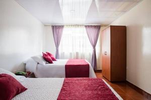 a bedroom with two beds and a window at Touristic House in Bogotá