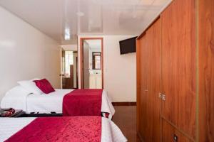 a hotel room with two beds and a cabinet at Touristic House in Bogotá