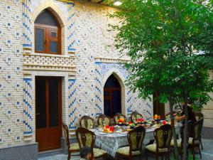 a table set for a meal in front of a building at Colibri Traditional Guest house in Samarkand