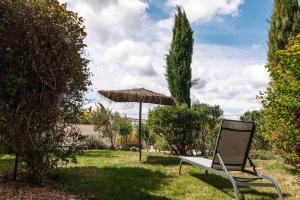 une chaise et un parasol dans l'herbe dans l'établissement Le Mas de Cink, à Saint-Saturnin-lès-Apt