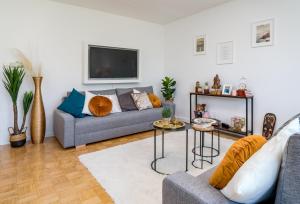 a living room with a couch and a tv at EG Links-Wunderschöne 70m große 2-Zimmer City Wohnung nähe Salzburg in Freilassing