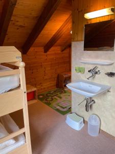 uma casa de banho com um lavatório e um beliche. em Chalet Sonnenröschen em Blatten bei Naters