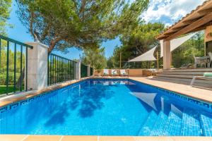 a swimming pool with a fence and a tree at Villa Cala Mesquida in Cala Mesquida