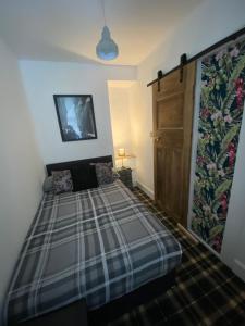 1 dormitorio con 1 cama y puerta de madera en Glasgow City Centre Apartment en Glasgow