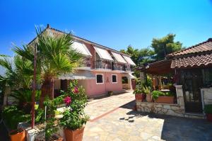 a courtyard of a house with plants and trees at Artemis Vassilikos in Vasilikos