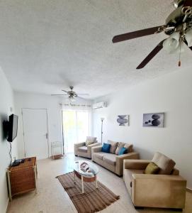 a living room with two couches and a ceiling fan at 2 bedroom townhouse, close to Paphos harbour, use of onsite facilities in Paphos