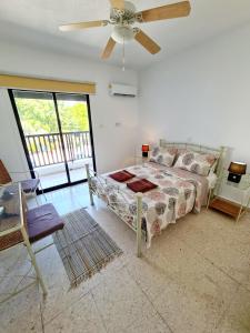 a bedroom with a bed and a ceiling fan at 2 bedroom townhouse, close to Paphos harbour, use of onsite facilities in Paphos
