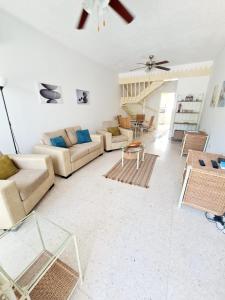 een woonkamer met een bank en een tafel bij 2 bedroom townhouse, close to Paphos harbour, use of onsite facilities in Paphos City