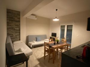 a living room with a couch and a table at Davidana Deluxe Apartments in Nea Kallikrateia