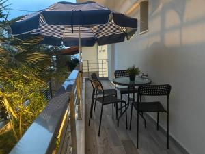 a patio with a table and chairs and an umbrella at Davidana Deluxe Apartments in Nea Kallikrateia