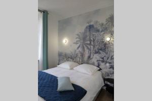 1 dormitorio con 1 cama con una pintura en la pared en Dinan Château - Parking inclus, en Dinan