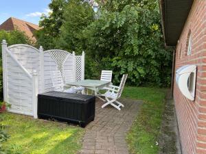 a patio with a table and chairs and a fence at Ferienwohnung Klintum in Oldsum