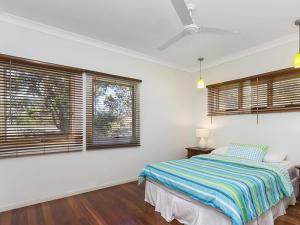 a bedroom with a bed and two windows at Absolute in Point Lookout