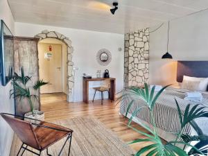 帕绍Boutique Hotel Morgentau的一间卧室配有一张床、一张桌子和植物