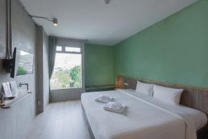 a bedroom with a white bed and white walls at EcoLoft Hotel - SHA Plus in Phuket
