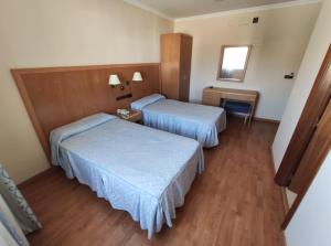 Habitación de hotel con 2 camas y espejo en Hotel Lindaraja en Atarfe