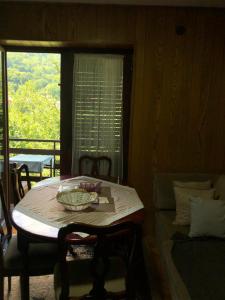 a table and chairs in a room with a window at Holiday Home Zbilje in Visoko
