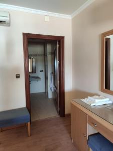 Hotel Lindaraja في Atarfe: حمام به مكتب ومرآة ومغسلة