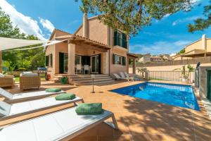 a backyard with a swimming pool and a house at Villa Cala Mesquida in Cala Mesquida