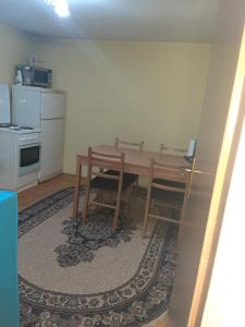 a kitchen with a wooden table and a kitchen with a stove at Stari Grad Migy Travnik Apartman in Travnik