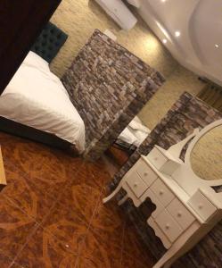 a view of a bedroom with a bed and a table at شاليه ايدوس in Obhor
