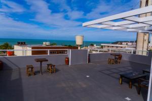 a rooftop patio with chairs and a view of the ocean at Economy Hotel in Natal