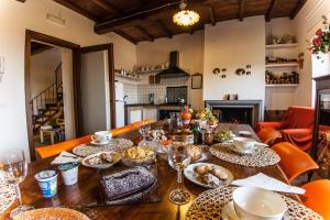 una mesa de madera con comida y copas de vino. en B&B Del Prato, en Bagnoregio