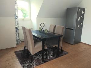 a dining room table with chairs and a refrigerator at Jenny's Ferienwohnung in Monschau