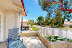 a blue bench sitting on the porch of a house at Easy Living Palm Desert in Palm Desert