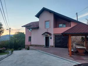 a pink house with a garage in front of it at Villa Amir in Sarajevo
