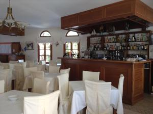 a restaurant with white tables and chairs and a bar at Astir Of Naxos in Naxos Chora