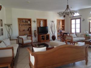 a living room with white furniture and a tv at Astir Of Naxos in Naxos Chora