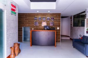 a lobby with a bar and a couch and a wall at Economy Hotel in Natal